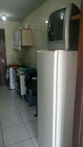 a television on top of a refrigerator in a kitchen at ILHA DOS CORAIS -Ap 304 C in Balneário Praia do Leste +16 photos