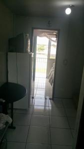 a kitchen with a refrigerator and a table and a door at ILHA DOS CORAIS -Ap 304 C in Balneário Praia do Leste