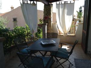 a table and chairs on a balcony with an umbrella at Graziosissima villa in Capitana