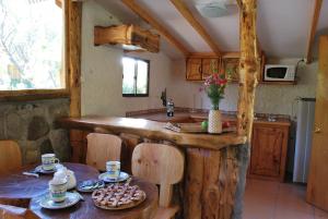 a kitchen with a wooden counter and a table at Tres Continentes in San José de Maipo