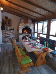 a dining room with a table and a fireplace at Ljudina in Kupres