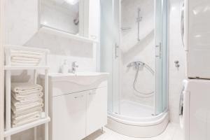 a white bathroom with a shower and a sink at City Center Pearl in Zagreb