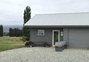 a gray house with a bench in front of it at Clydestay in Alexandra