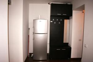 布加勒斯特的住宿－Grand Central Accomodation Sala Palatului，厨房配有冰箱和黑色橱柜。