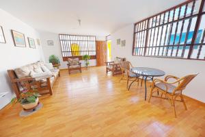 a living room with a table and chairs at Punta Huanchaco Hostel in Huanchaco