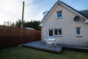a patio with two chairs and a table in front of a house at Alma Villa in Falkirk