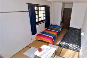 a room with a rainbow bed and a window at Chalet Madarao in Iiyama