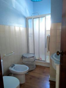 a bathroom with a shower and a toilet and a sink at Laurel Beach House in Lourinhã