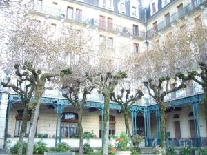 a row of trees in front of a building at Studio curiste aix les bains in Aix-les-Bains