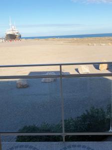 uma varanda com vista para a praia e um barco em Barcaresa-Villa Vue Mer Accès Direct Plage - Piscine em Le Barcarès