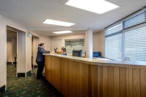 a man standing at a counter in an office at Bow View Lodge in Banff