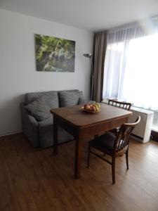 バート・ウーラッハにあるFREE Apartment - Schönblickのリビングルーム(テーブル、ソファ付)
