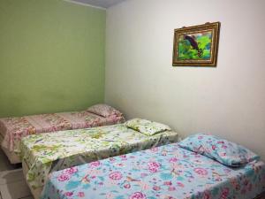 クイアバにあるPousada CPAのベッド2台が備わる部屋、壁に絵が飾られた部屋
