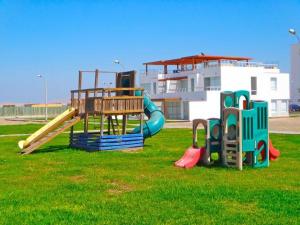 a group of playground equipment in a grass field at Dpto de playa en Paracas in Paracas