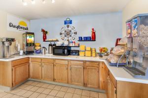 a kitchen with wooden cabinets and a counter top at Days Inn by Wyndham Kent - Akron in Kent