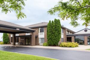 un bâtiment avec un parking en face de celui-ci dans l'établissement Days Inn by Wyndham Johnson Creek, à Johnson Creek