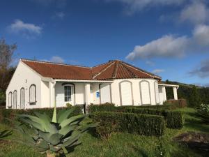 ein weißes Haus mit braunem Dach in der Unterkunft Villa Ferreirinha in Santa Cruz das Flores