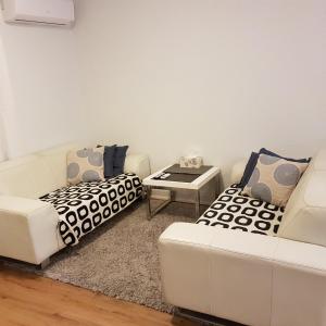 a living room with two white couches and a table at Freo for Two in Fremantle