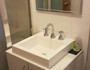 a white sink in a bathroom with a mirror at Freo for Two in Fremantle