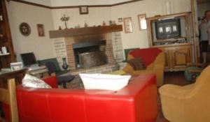 a living room with a red couch and a fireplace at Le Puits Fortifié in Salives