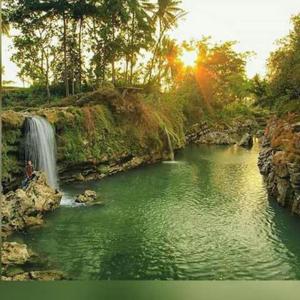 a waterfall in the middle of a river at The New Orlinds Guest House in Wonosari