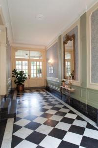 a large room with a checkered floor and a mirror at La Porte Cochère in Ypres