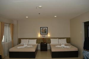 a hotel room with two beds and a couch at Columbus Plaza Hotel in General Santos +29 photos
