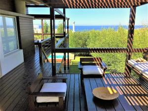 una terraza con bancos y vistas al océano. en Best Vila in Manantiales - El Chorro, en Manantiales