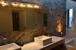 baño con 2 lavabos y espejo grande en Best Vila in Manantiales - El Chorro, en Manantiales