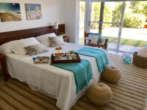 Un dormitorio con una cama con una bandeja de comida. en Best Vila in Manantiales - El Chorro, en Manantiales