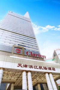 un edificio alto con un cartel delante en Clarion Hotel Tianjin, en Tianjin