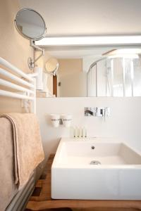 W łazience znajduje się biała umywalka i lustro. w obiekcie LEO Appartements w Mayrhofen
