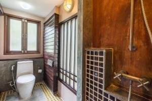 a bathroom with a toilet and a window at Cocohut Beach Resort Koh Phangan in Haad Rin