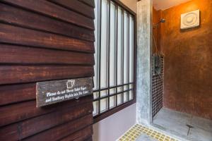a sign on the wall of a building with a balcony at Cocohut Beach Resort Koh Phangan in Haad Rin