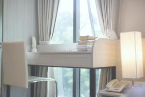 a desk with a phone next to a window at Park 19 Hotel in Bangkok