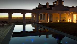 a villa with a swimming pool at sunset at Estancia VIK José Ignacio in José Ignacio