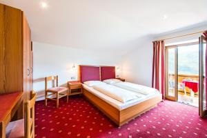 a bedroom with a large bed and a large window at Pension Stamserhof in Nalles