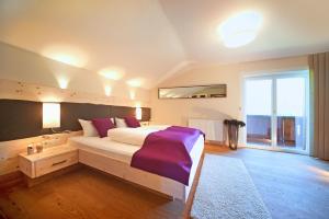 sypialnia z dużym łóżkiem i dużym oknem w obiekcie LEO Appartements w Mayrhofen