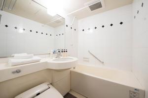 a white bathroom with a sink and a toilet at Hotel Villa Fontaine Tokyo-Hamamatsucho in Tokyo