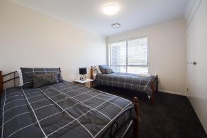 1 dormitorio con 2 camas y ventana en Executive Home Accommodation 34, en Bundamba