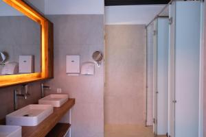 a bathroom with two sinks and a shower at M Boutique Hostel Legian in Legian +54 photos