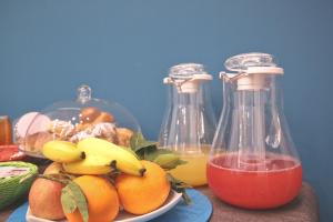 a bowl of fruit and two bottles of juice at La Baia Di Partenope in Naples