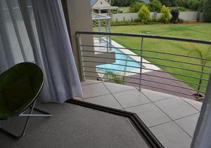 a balcony view of a patio with a view of the water at Dante Deo Guesthouse in Bloemfontein