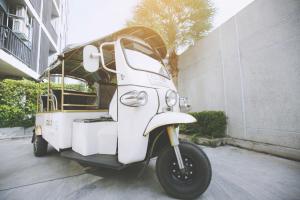 a white motor scooter parked next to a building at Park 19 Hotel in Bangkok