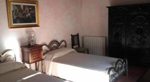 a bedroom with two beds and a dresser and a picture at Casa Cossio in Jaén