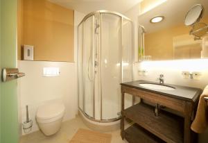 y baño con ducha, aseo y lavamanos. en LEO Appartements, en Mayrhofen