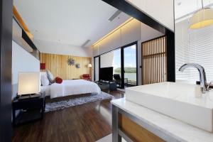 a bedroom with a bed and a tub and a sink at Midori Clark Hotel and Casino in Clark