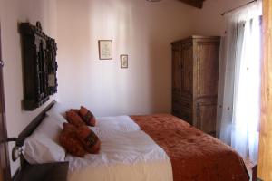 a bedroom with a bed and a wooden cabinet at Casa Rural El Zahorí De Pinedas in Pinedas