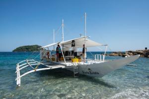 un barco sentado en el agua en el océano en Punta Bulata White Beach Resort & Spa, en Sipalay