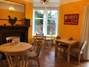 a dining room with two tables and a chicken on the wall at The Hive at 52 in Northwich